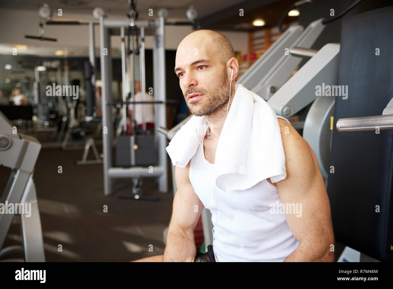 Portrait of sporty man sitting and relaxing after workout in the gym. Stock Photo