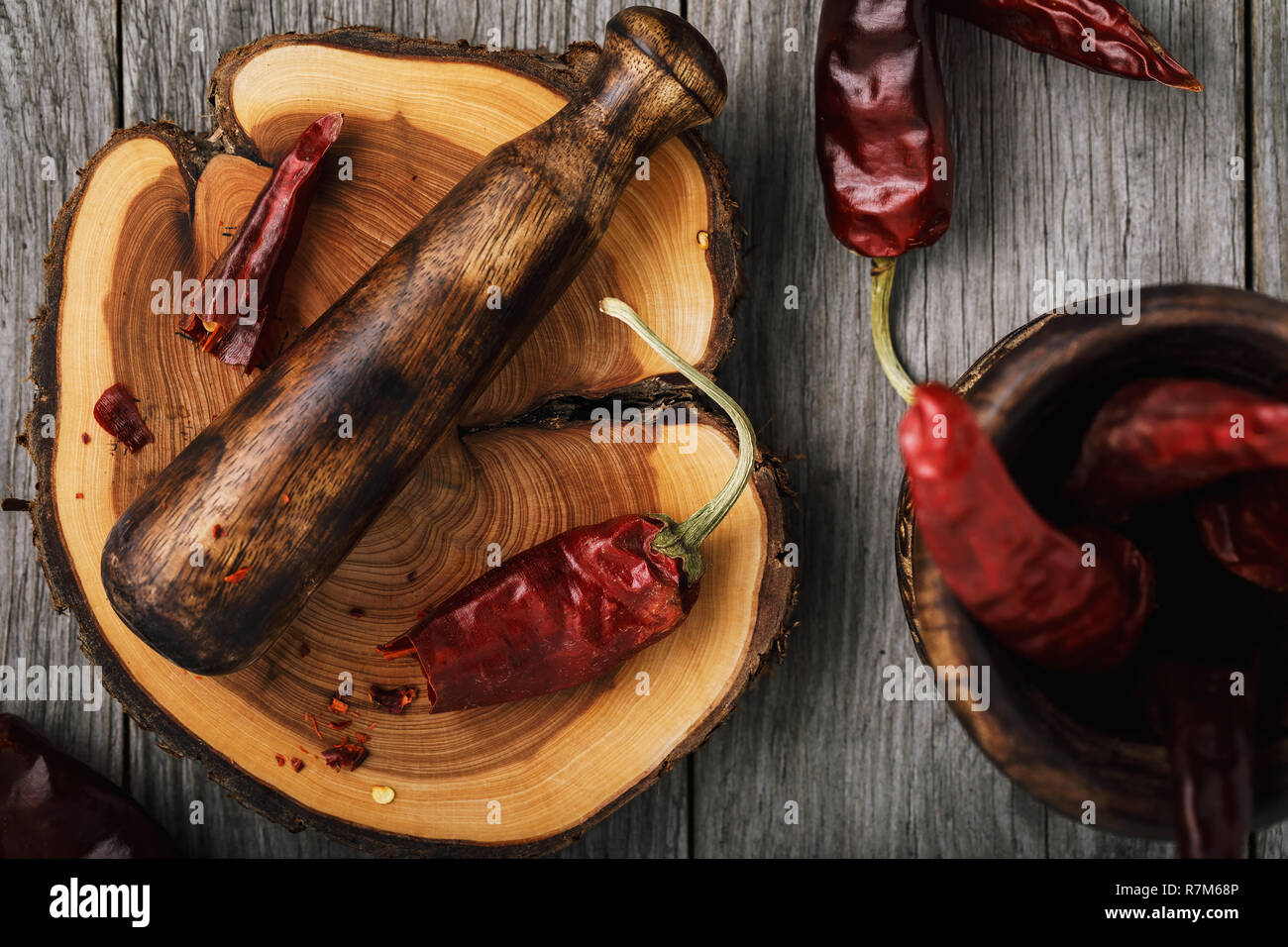 Dried pepper and kitchen chopper on wooden stand close-up, top view ...