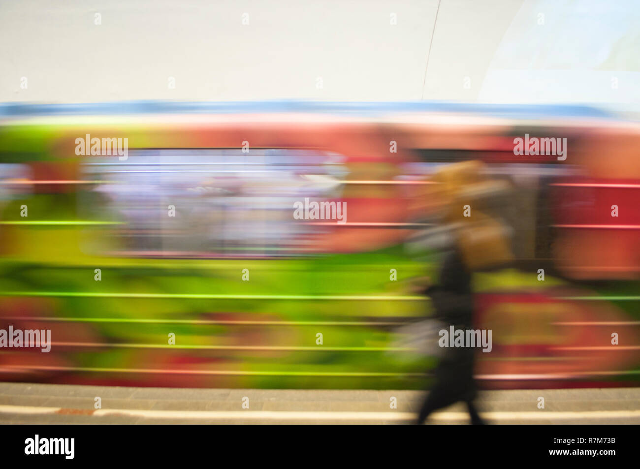 Blurred motion of the colorful train with living coral color elements in an underground station. Stock Photo
