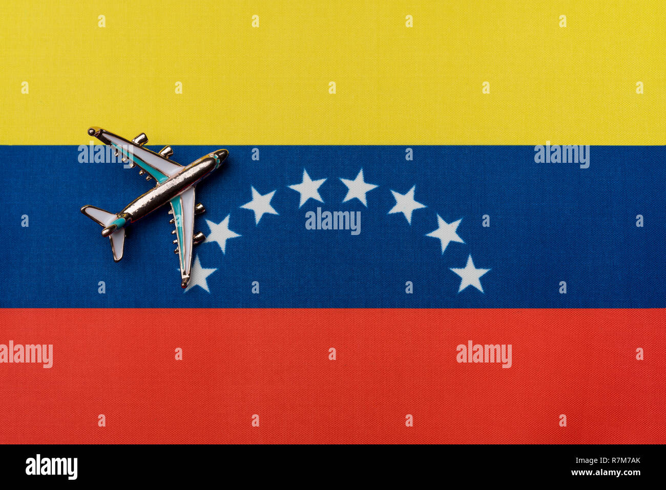 The plane over the flag of Venezuela, the concept of travel. Toy plane on the flag as a background. Stock Photo