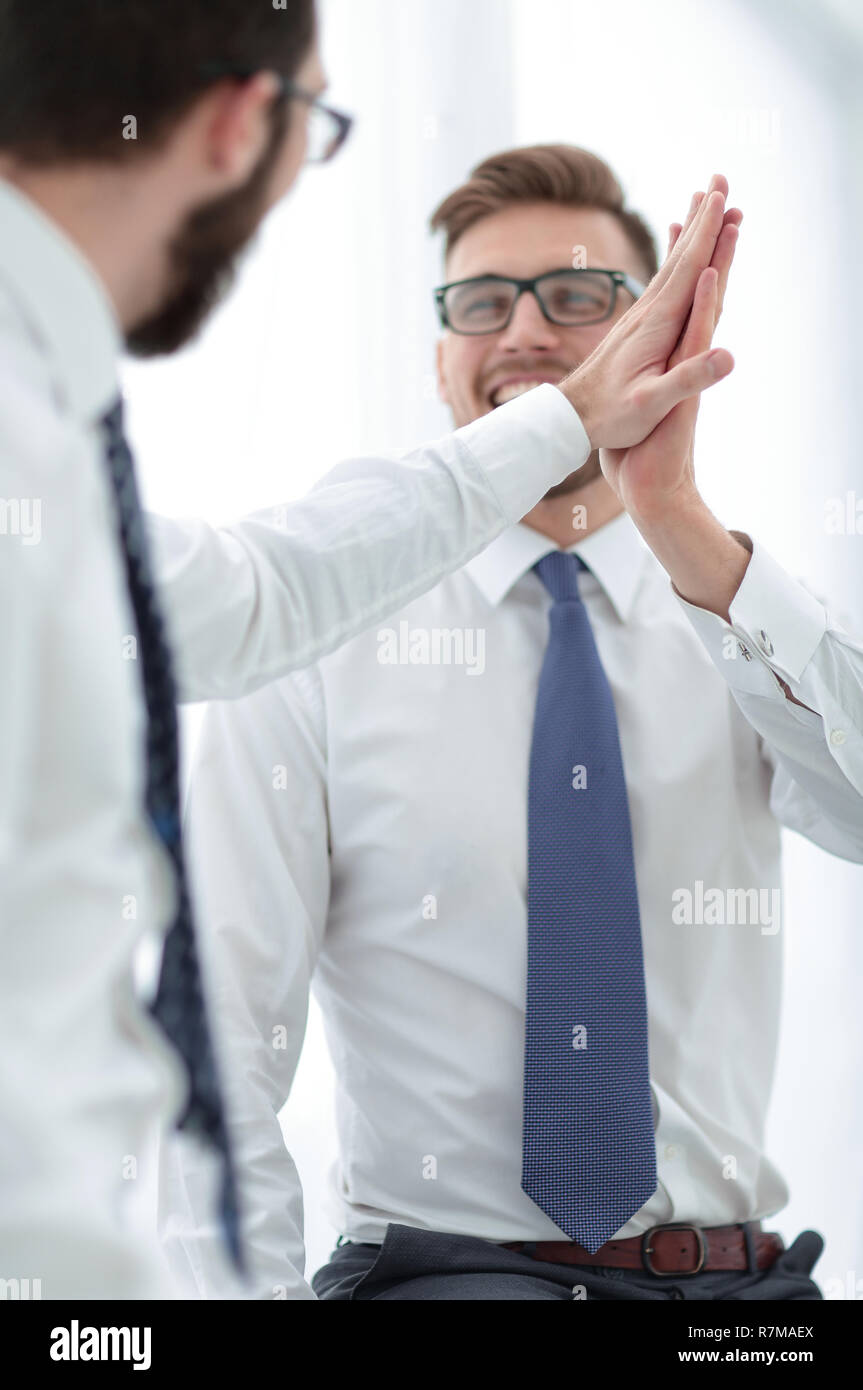 close up. smiling employees giving each other a high five Stock Photo ...