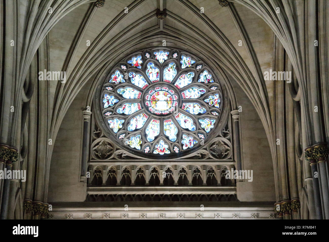 The main rose window under the pointed arch vault with colored stained glasses and Gothic decorations in the Bristol Cathedral, United Kingdom Stock Photo