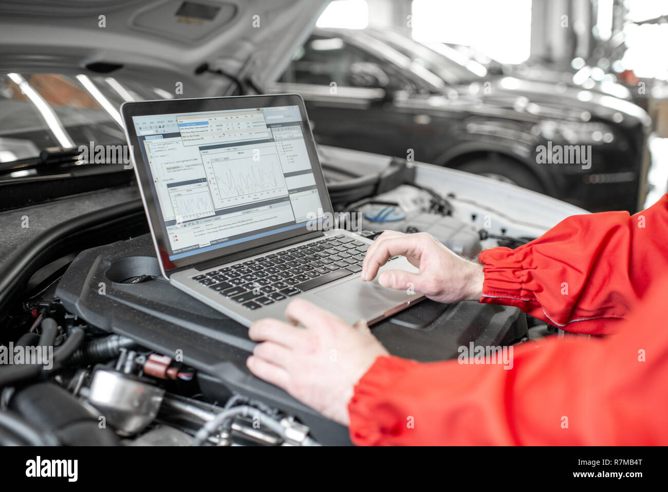 Auto mechanic diagnosing car engine with a laptop with special program,  close-up view with no face Stock Photo - Alamy