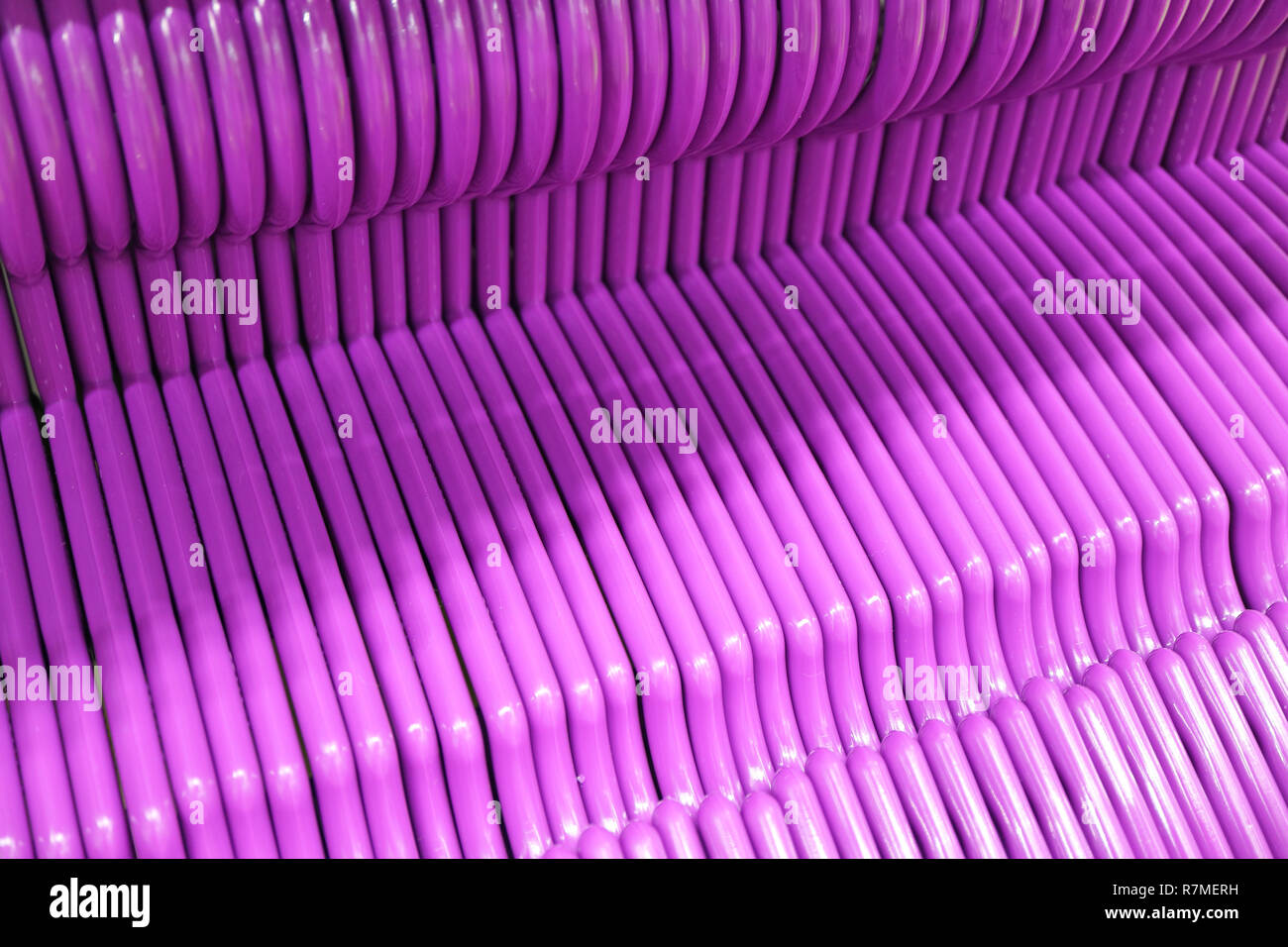 Lined Up Empty Vibrant Purple Clothes Hangers Stock Photo