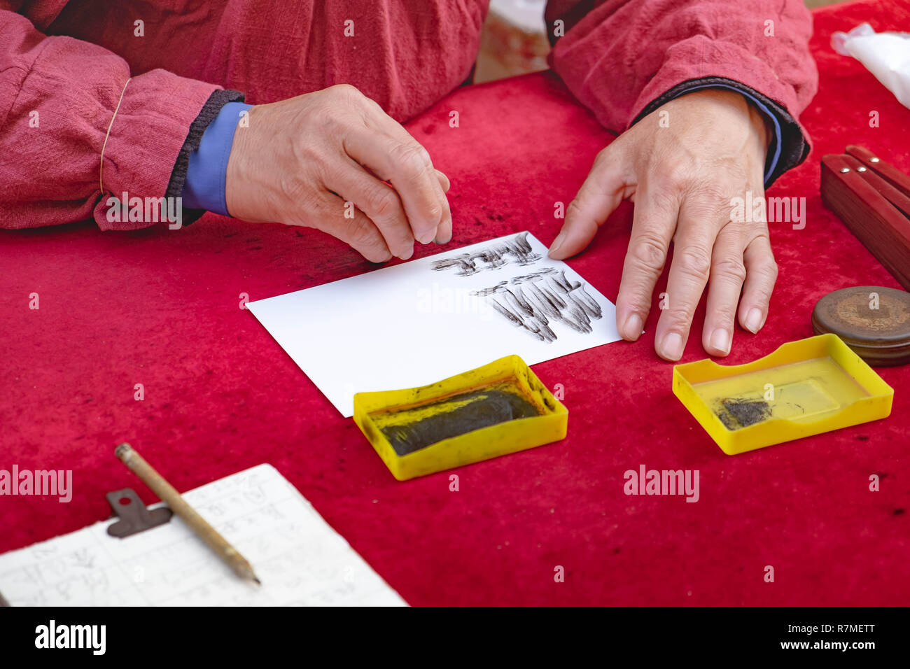 Chibi, Hubei/ CHINA - OCT 25, 2018:  The Old man use carbon powder for drawing picture with his finger. And the picture is concern about the Chinese s Stock Photo