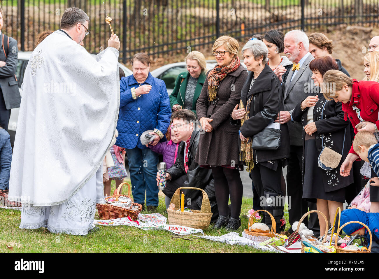 Washington DC, USA - April 1, 2018: People, priest praying, holding sprinkling holy water, Easter baskets at Ukrainian Catholic National Shrine of Hol Stock Photo