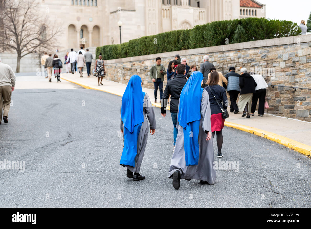 Washington DC, USA - April 1, 2018: People blue nuns walking by the basilica of the National Shrine of the Immaculate Conception Catholic church stree Stock Photo