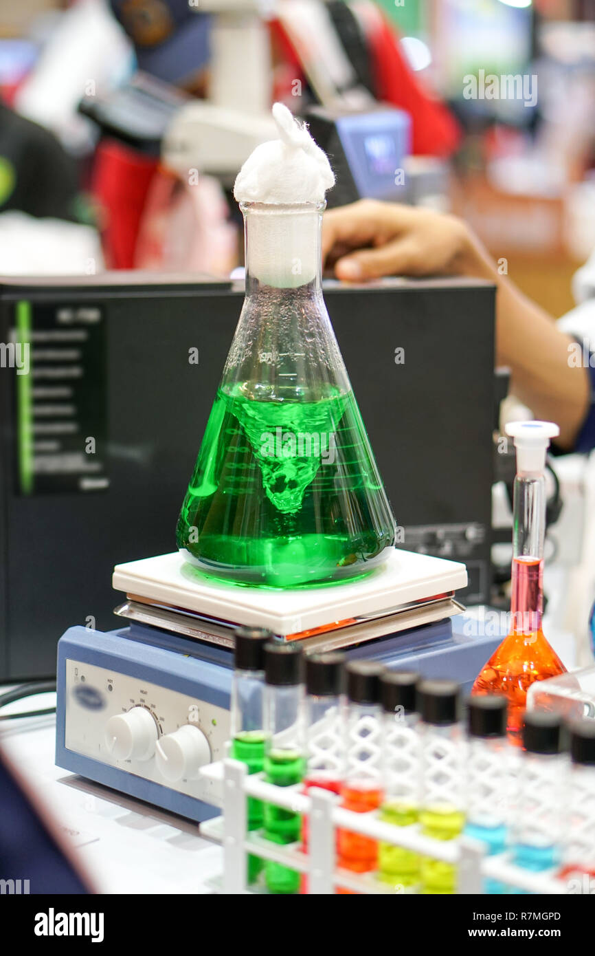 laboratory agitators. The green liquid is mixed in a conical