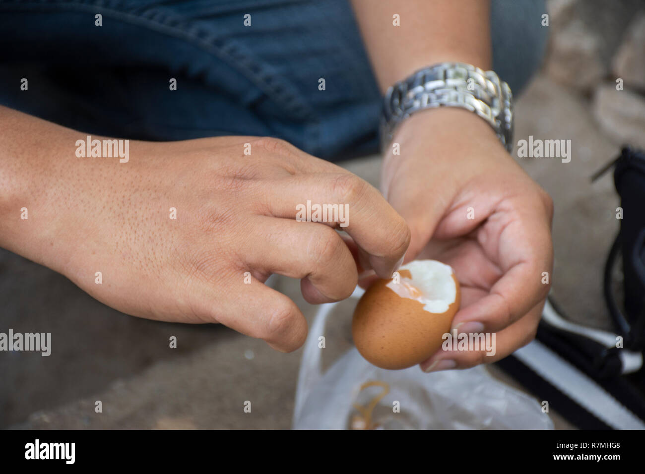 Thai man peeling shell boiled eggs after cooking boiling in hot spring of Pa Tueng Hot Spring at Mae Chan in Chiang Rai, Thailand Stock Photo