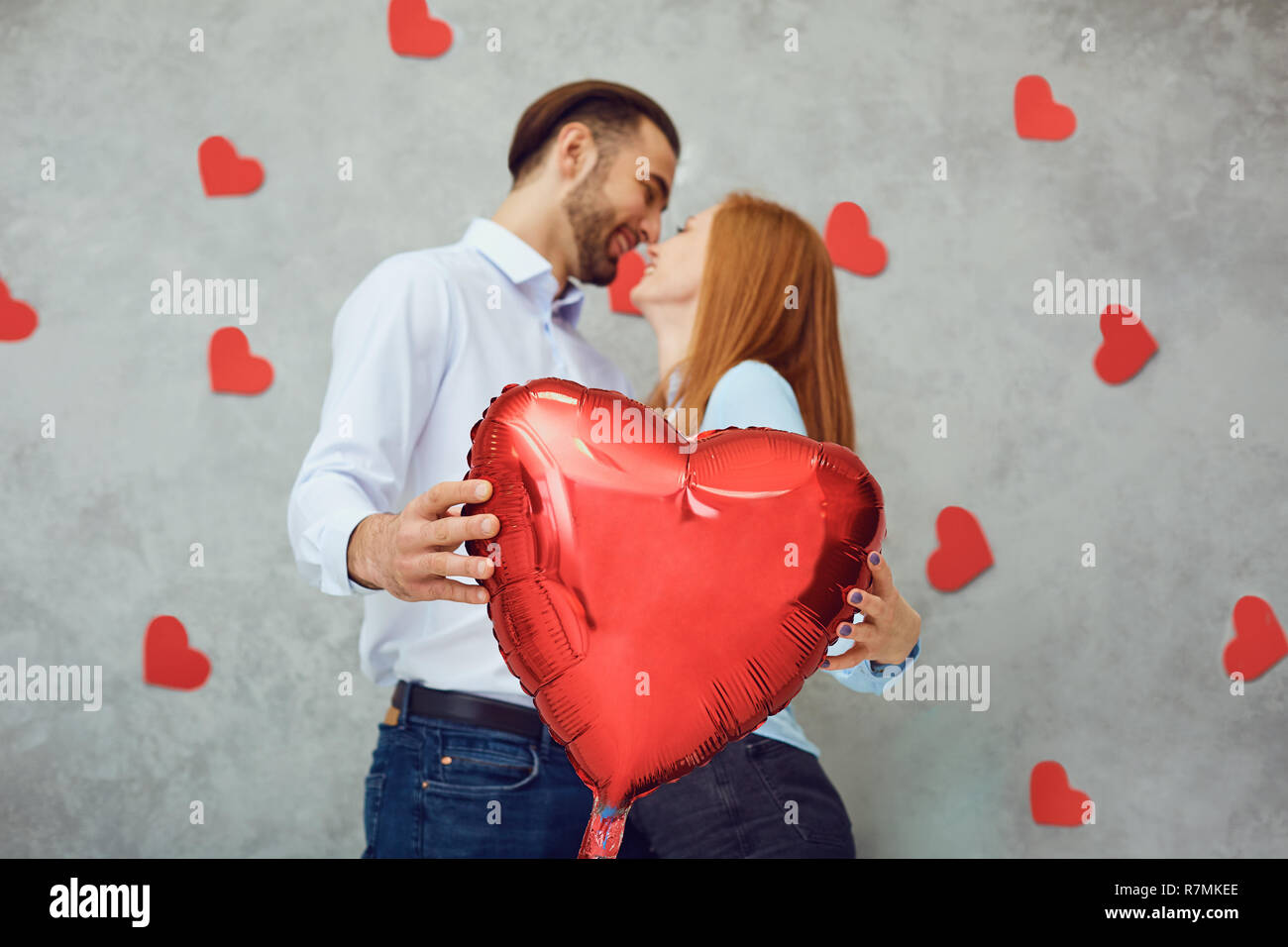 Couple with red heart balloon on a gray background.  Stock Photo