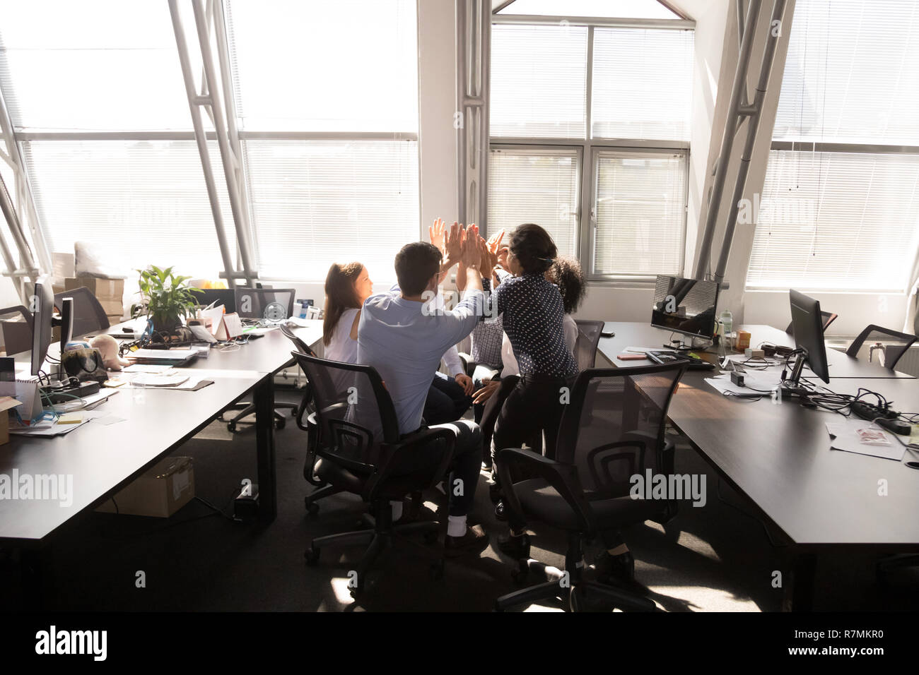 Multi-ethnic employees group giving high five at company meeting Stock ...
