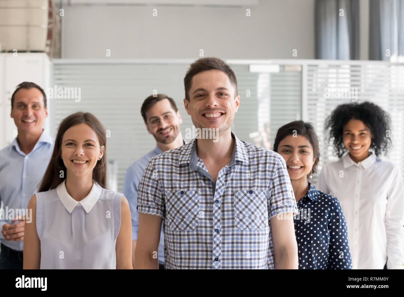 Happy male leader, coach posing with multiracial group of employ Stock Photo