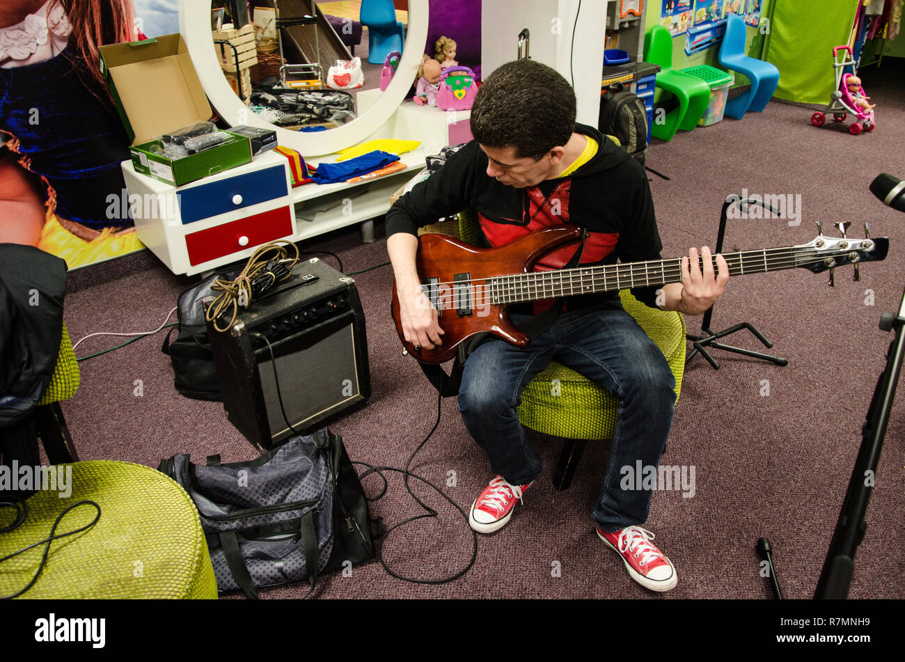 Singer Bass guitarist sitting testing his instrument Stock Photo Alamy
