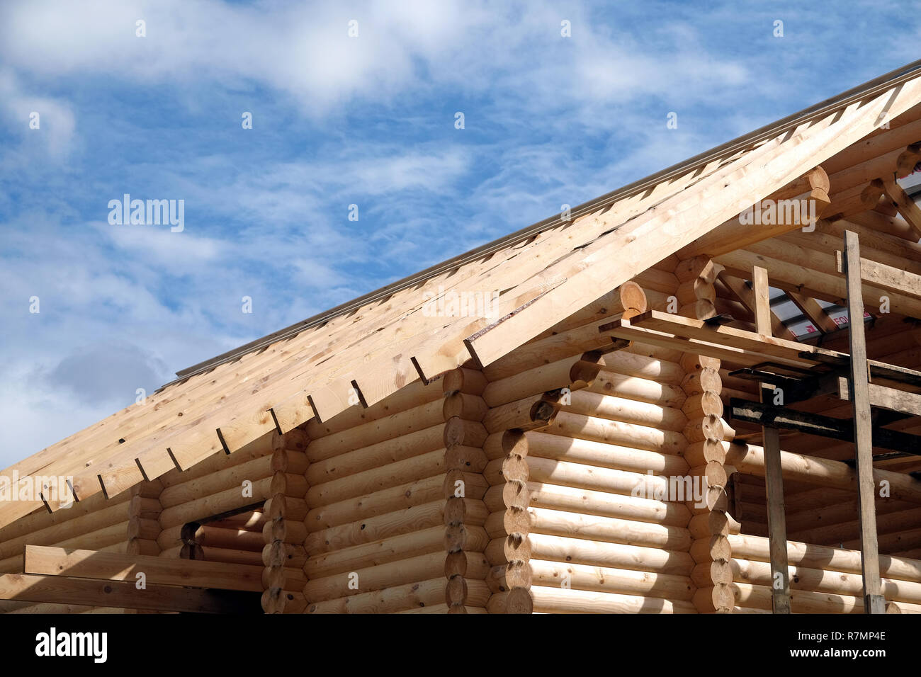 Process of wooden house straight roof slope mounting side view. Wooden country house construction Stock Photo