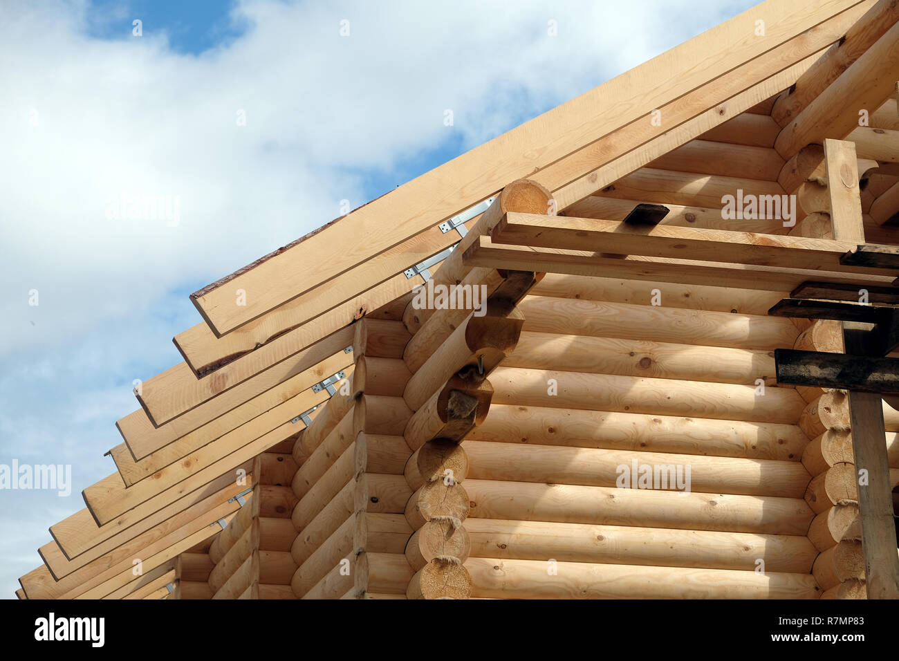 Process of wooden house straight roof slope mounting front view. Wooden country house construction Stock Photo