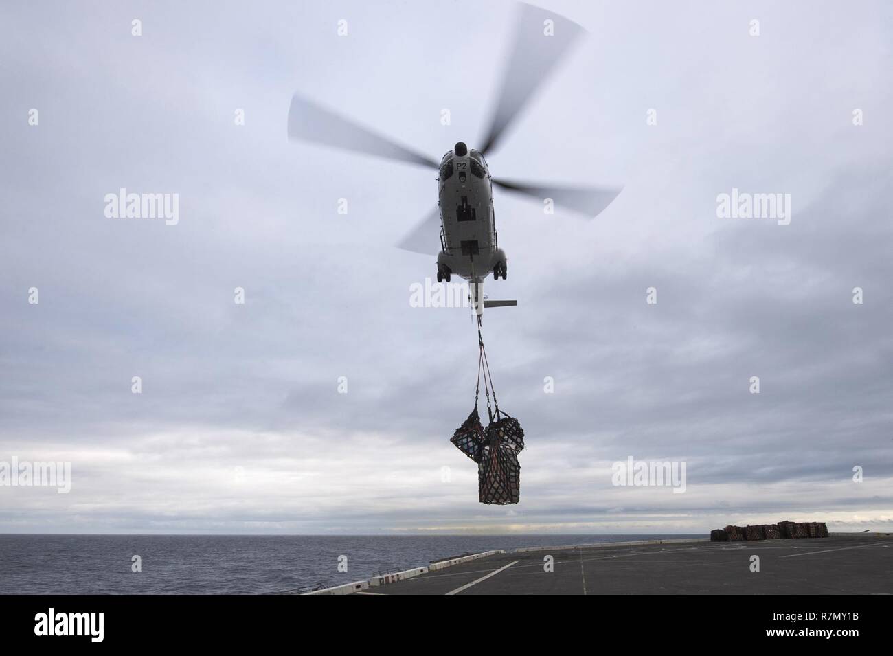EAST CHINA SEA (March 20, 2017) An SA-330J Puma helicopter, assigned to the Military Sealift Command dry cargo and ammunition ship USNS Richard E. Byrd (T-AKE 4), approaches the flight deck of the amphibious transport dock ship USS Green Bay (LPD 20) during a vertical replenishment. Green Bay, part of the Bonhomme Richard Expeditionary Strike Group, with embarked 31st Marine Expeditionary Unit, is on a routine patrol, operating in the Indo-Asia-Pacific region to enhance warfighting readiness and posture forward as a ready-response force for any type of contingency. Stock Photo