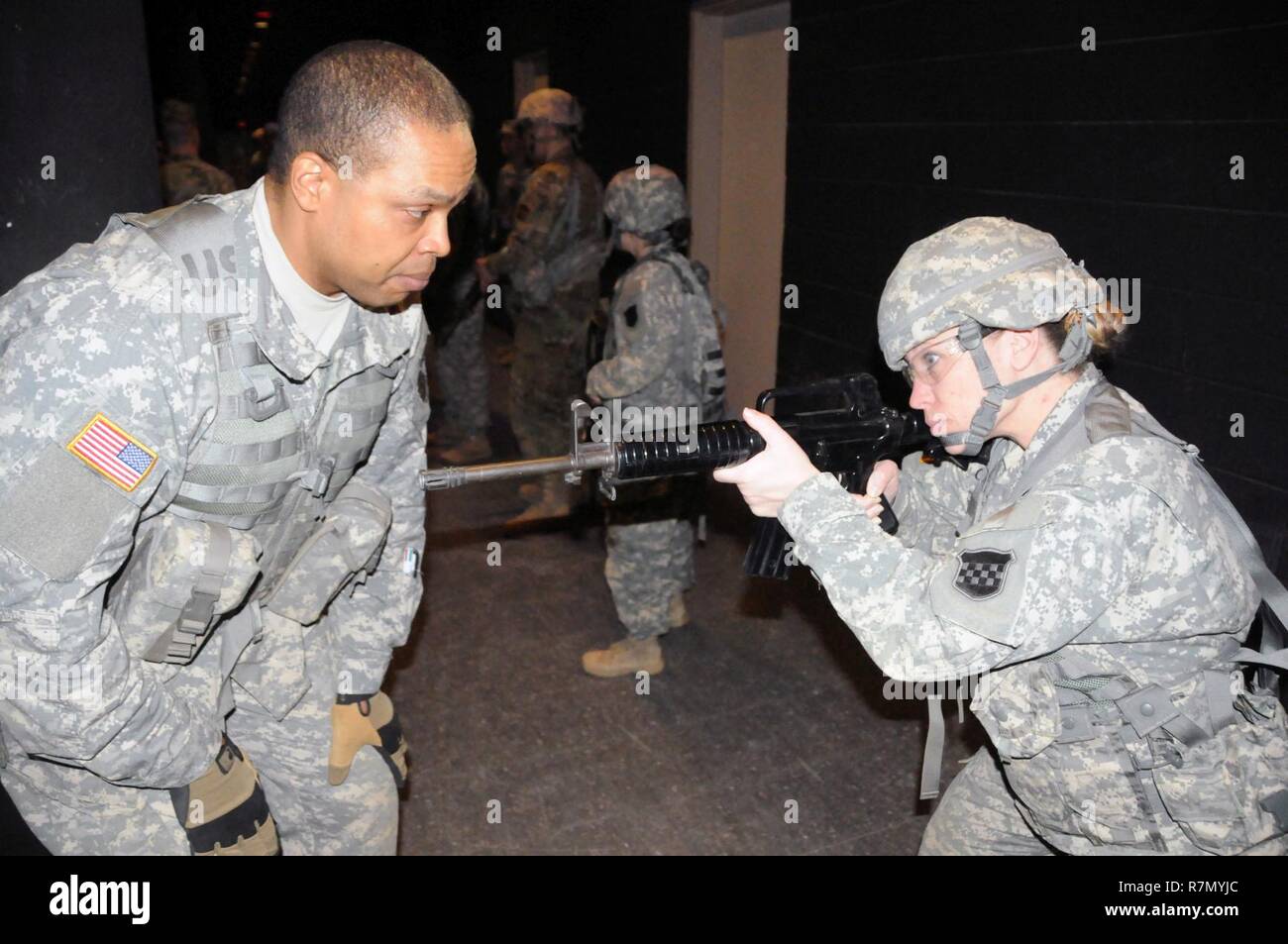 Sgt. 1st Class Peter Vines, acting first sergeant for the U.S. Army Reserve’s 318th Press Camp Headquarters, helps Staff Sgt. Carrie Castillo with proper weapon placement prior to conducting a dismounted patrol lane March 20 at the New Jersey National Guard’s Joint Training and Training Development Center on Joint Base McGuire-Dix-Lakehurst, New Jersey.  The training is part of the unit’s annual training which includes refresher courses on basic Soldier skills. Stock Photo