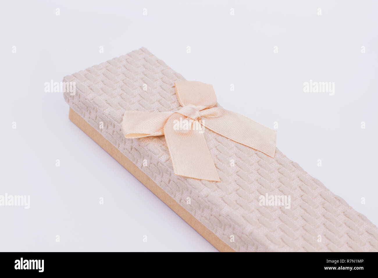 Beige jewelry gift box with ribbon. Chain gift box isolated. Jewelry