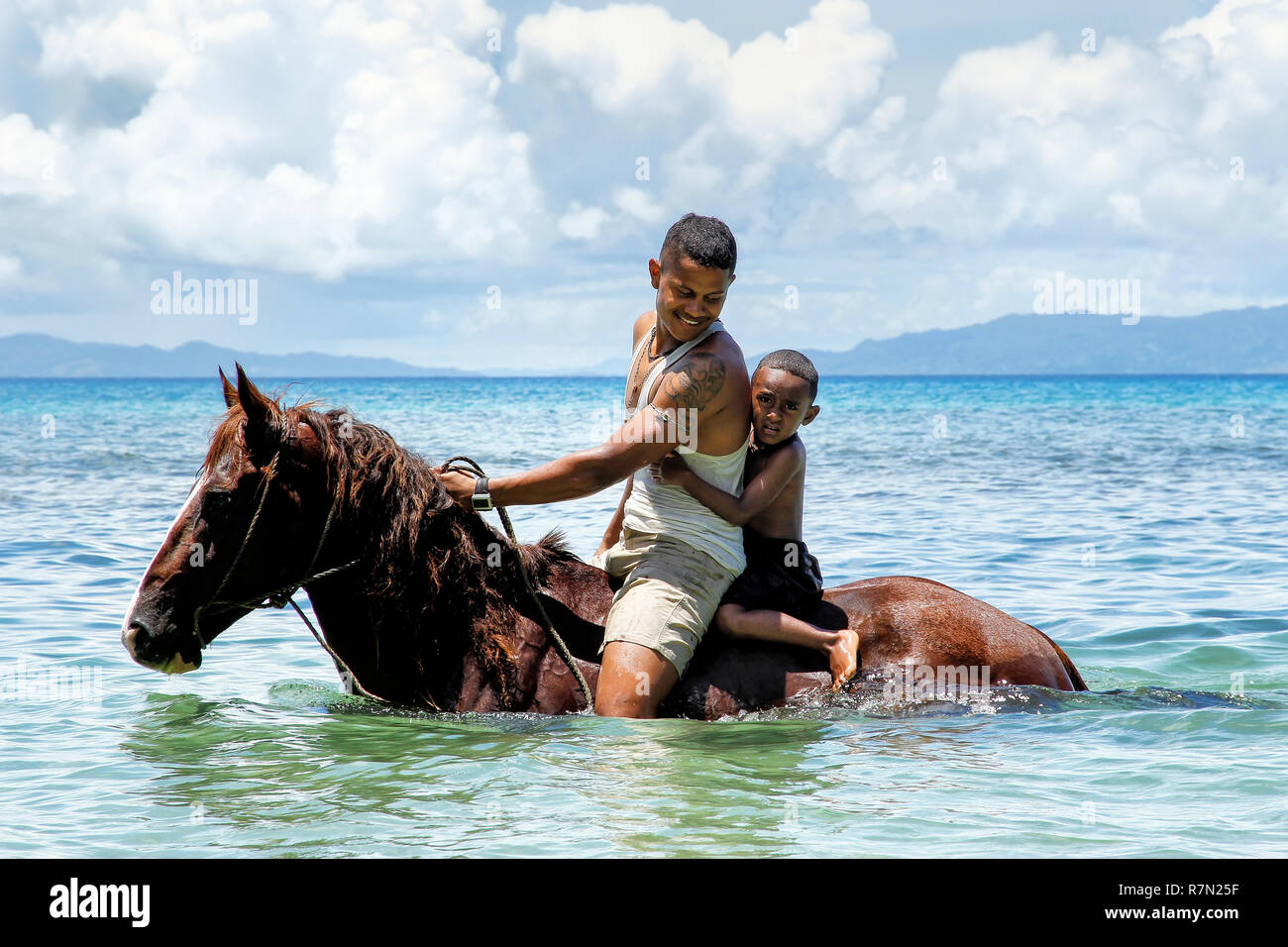 Young man with a boy riding horse on the beach on Taveuni Island, Fiji.  Taveuni is the third largest island in Fiji Stock Photo - Alamy