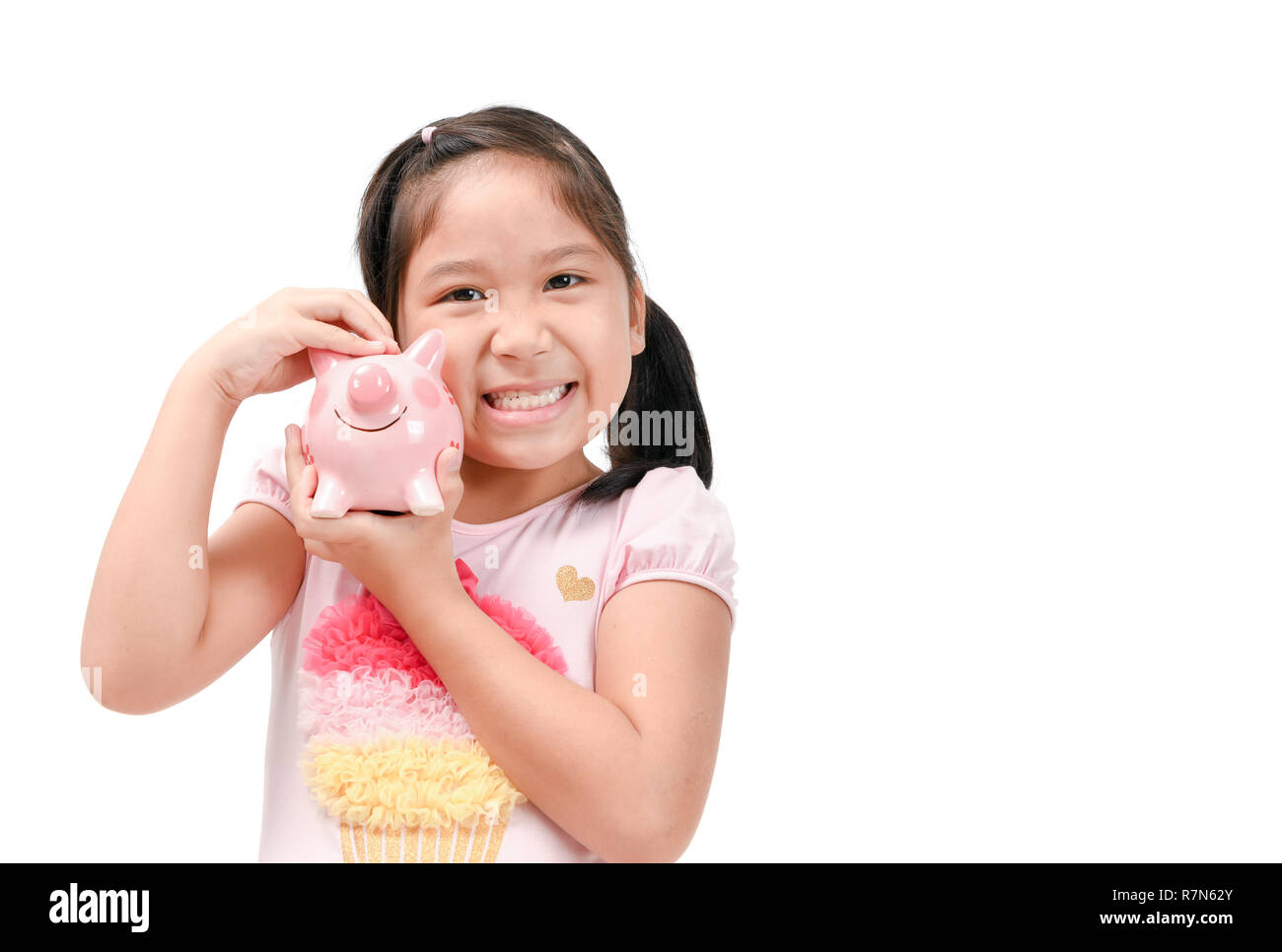 Happy cute asian girl holding pink piggy bank isolated on white ...