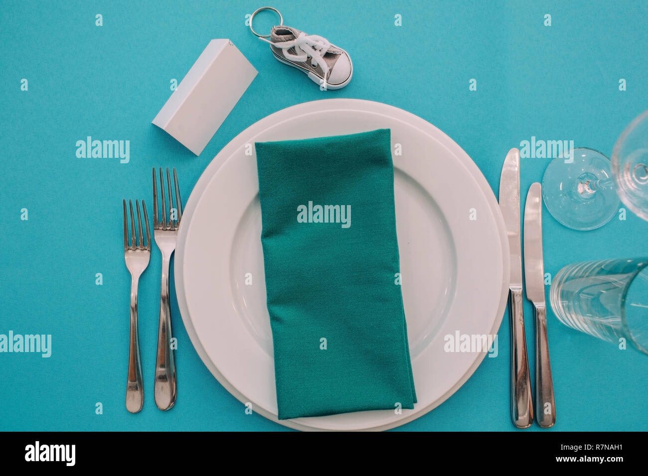 Dinner plate setting on a turquoise table , top view. Stock Photo