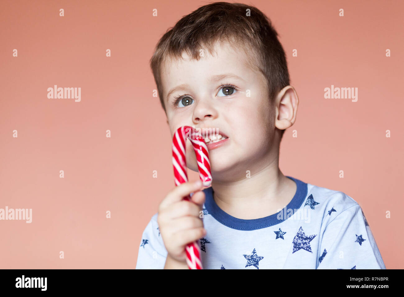 A cute boy eating candy sticks. Red White Striped Candy Cane Stock