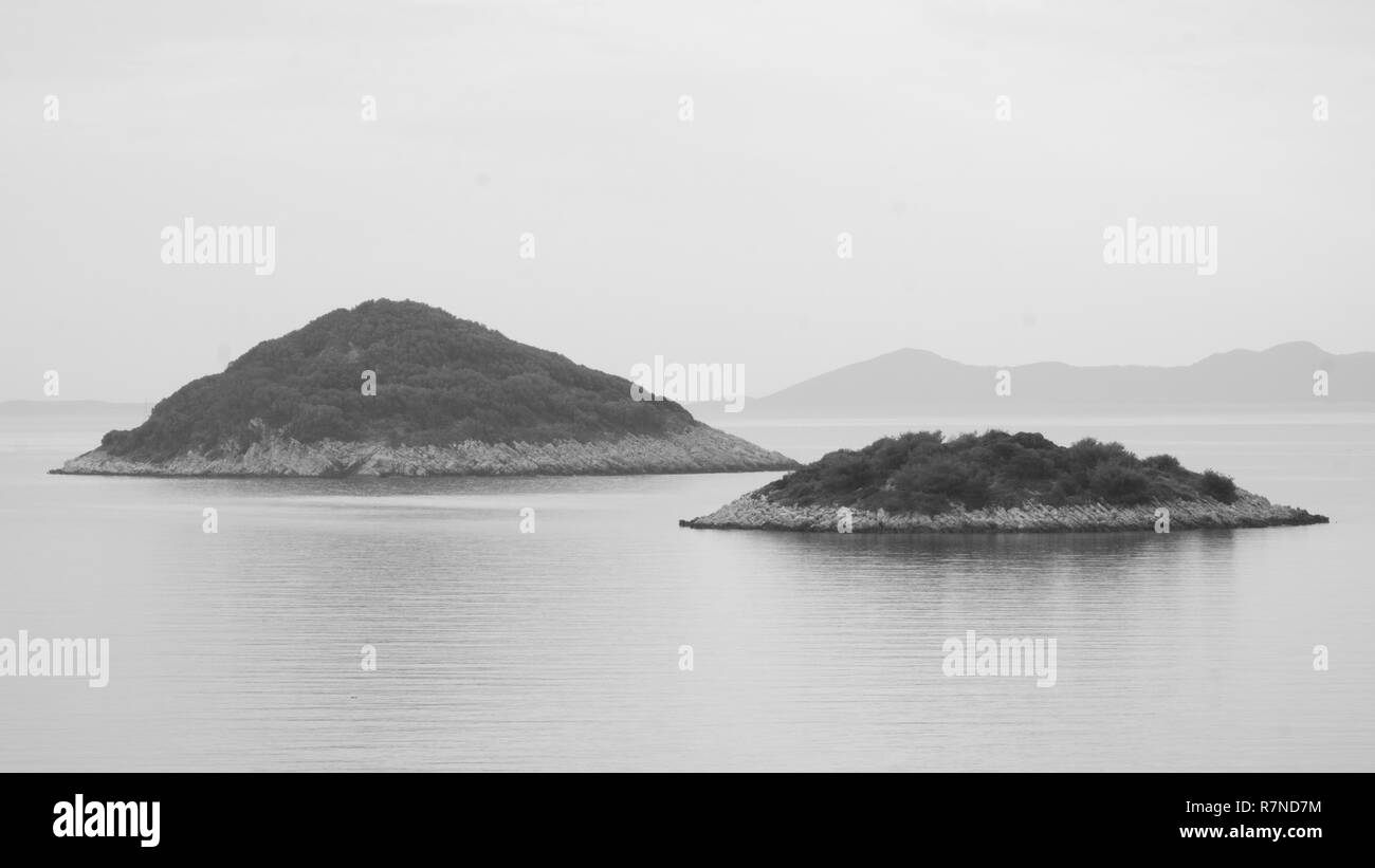 black and white high key view of two small, lonely island in the adriatic sea near korcula, croatia. Stock Photo