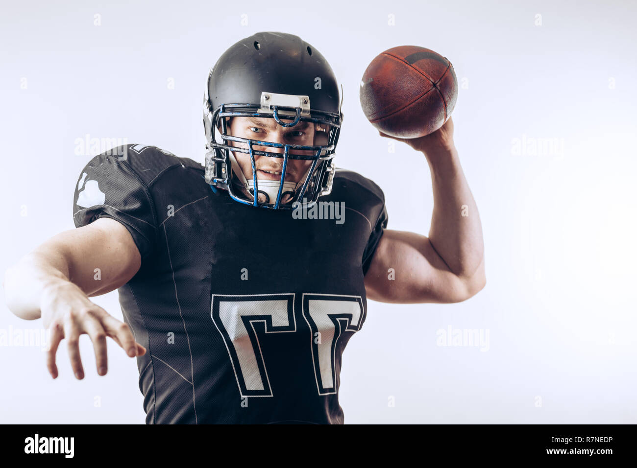 Quarterback throwing a football in a professional football game Stock
