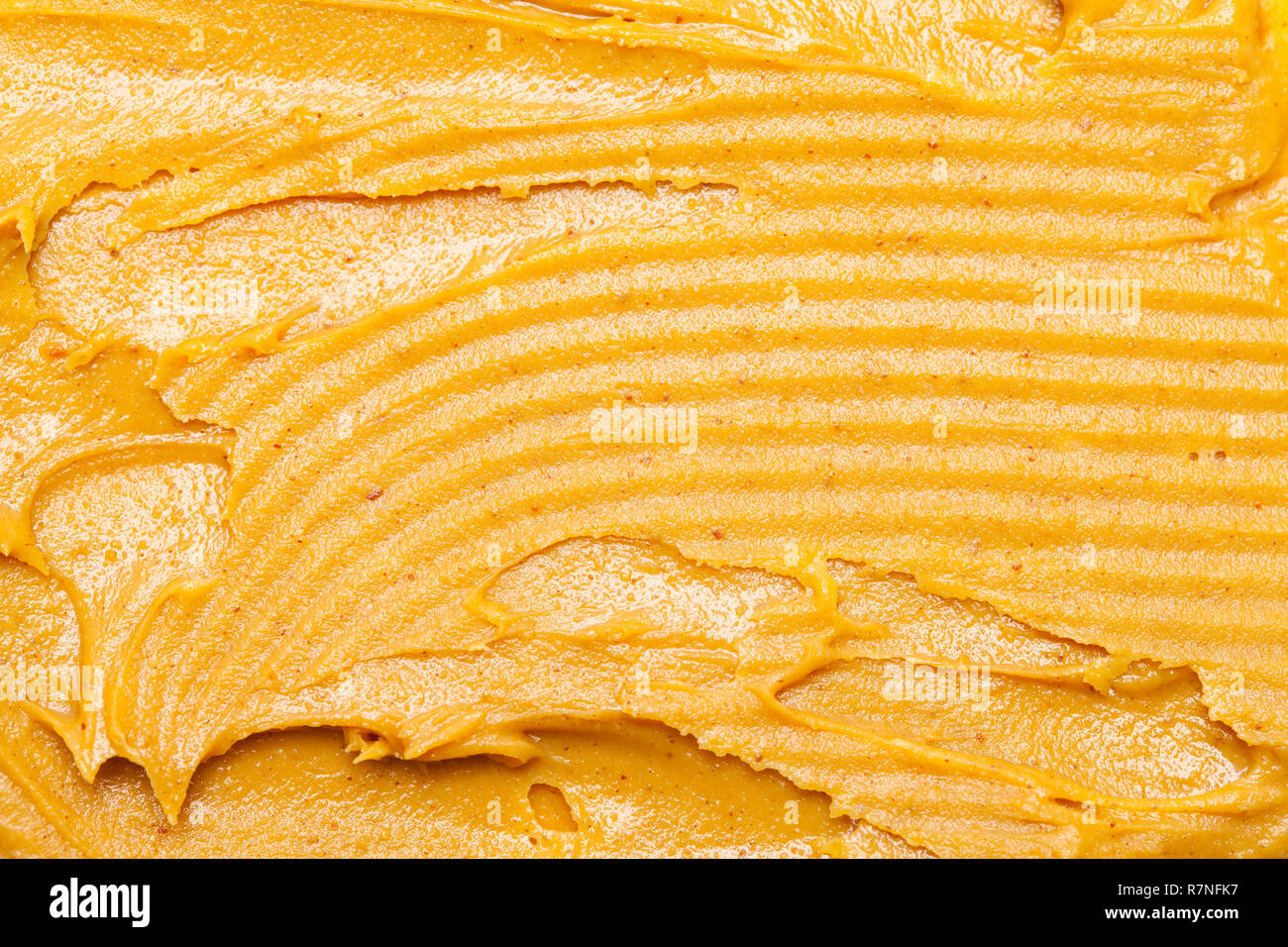 Smeared Peanut Butter Spread with Knife Grooves. Stock Photo