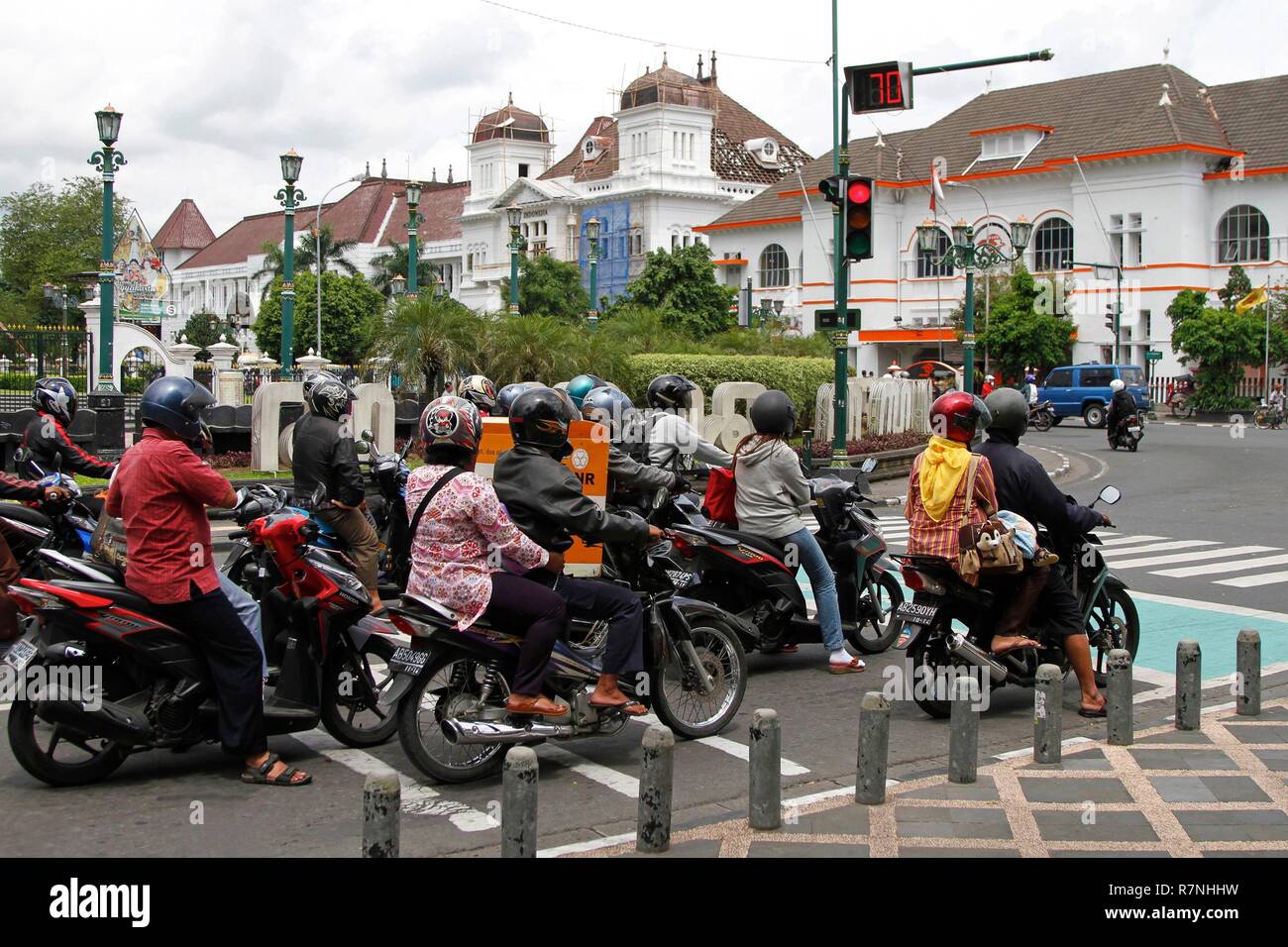 Indonesia, Java, Yogyakarta, Motocyclists at a red light in front of Dutch colonial buildings Stock Photo