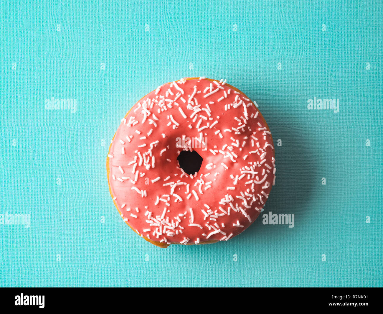 Color of year 2019 Living Coral concept. Donut with living coral glaze on blue background. Top view or flat lay. Copy space for text. Stock Photo