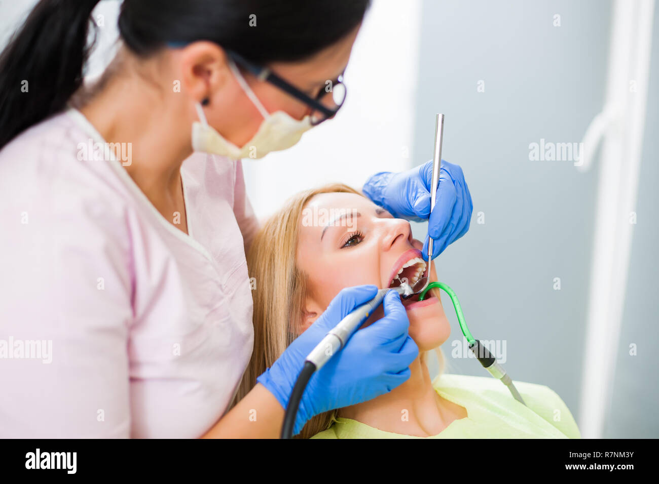 Young woman at dentist. Dentist is repairing her teeth Stock Photo Alamy
