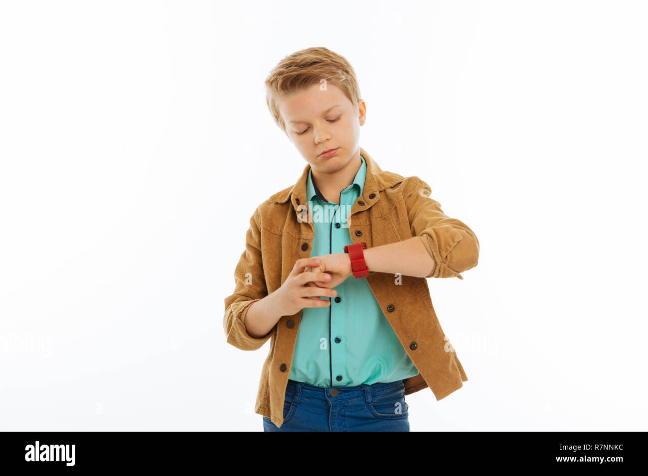 Serious confident boy looking at his watch Stock Photo