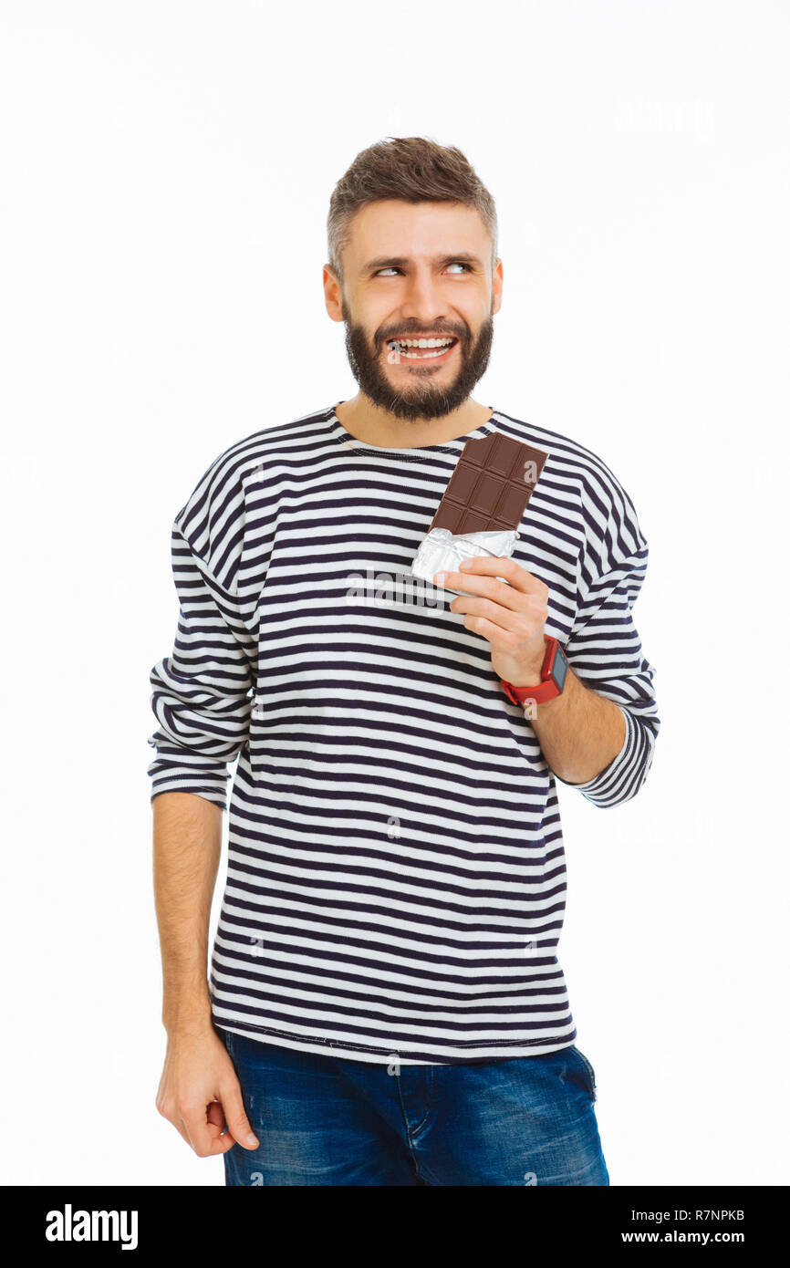 Positive handsome man enjoying his chocolate bar Stock Photo