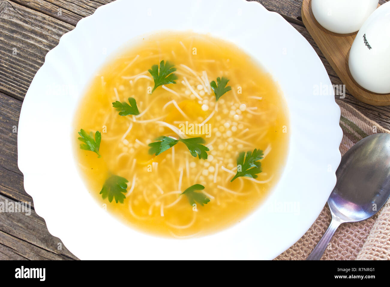 Clear soup in plate on old wooden table Stock Photo