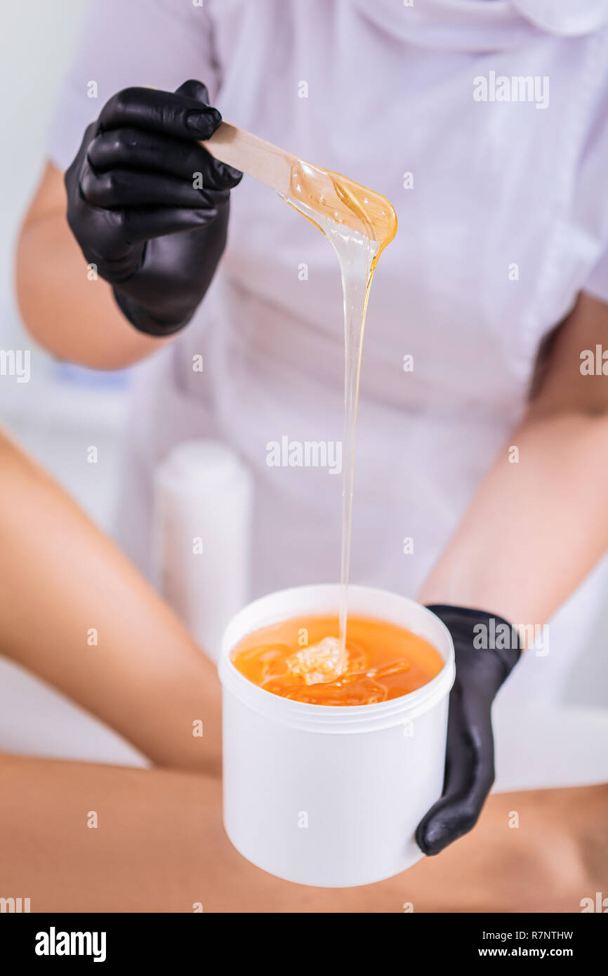 Close up of depilation master holding wax for depilation Stock Photo