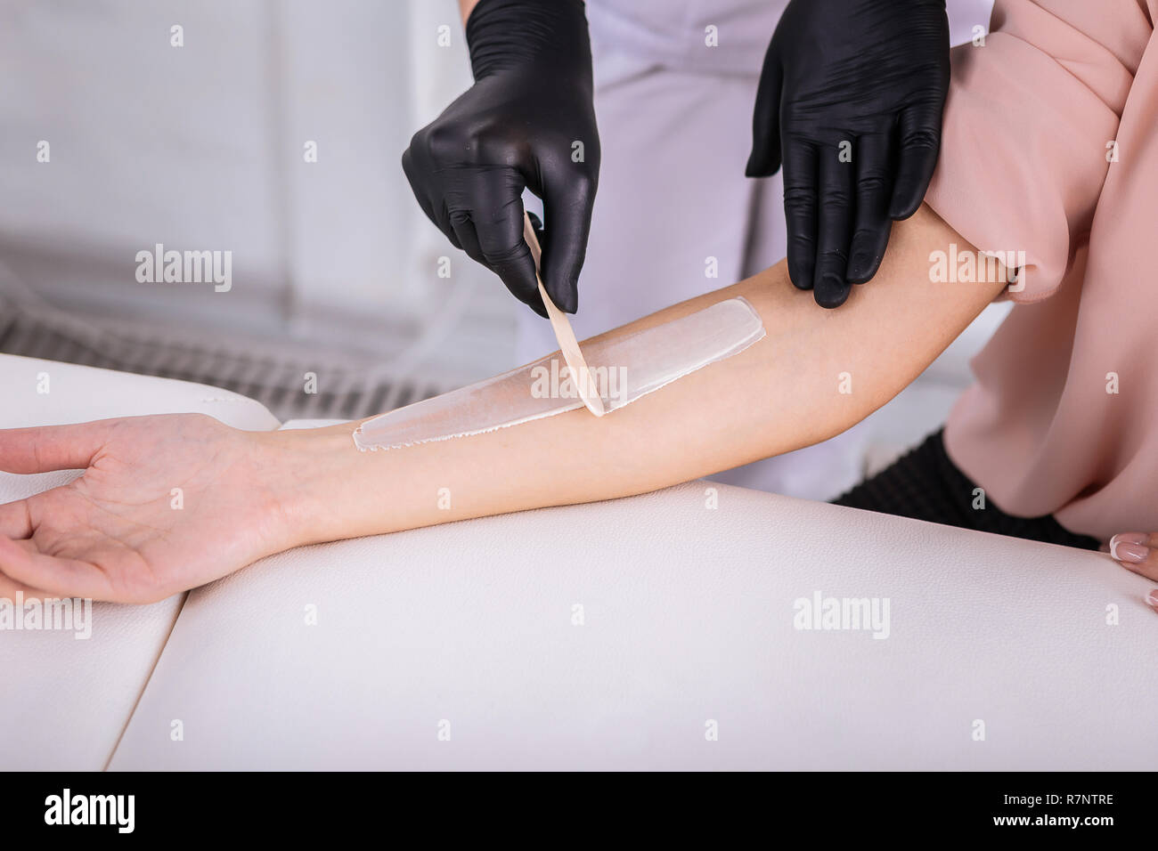 Master in hair removal putting depilatory cream on arms Stock Photo