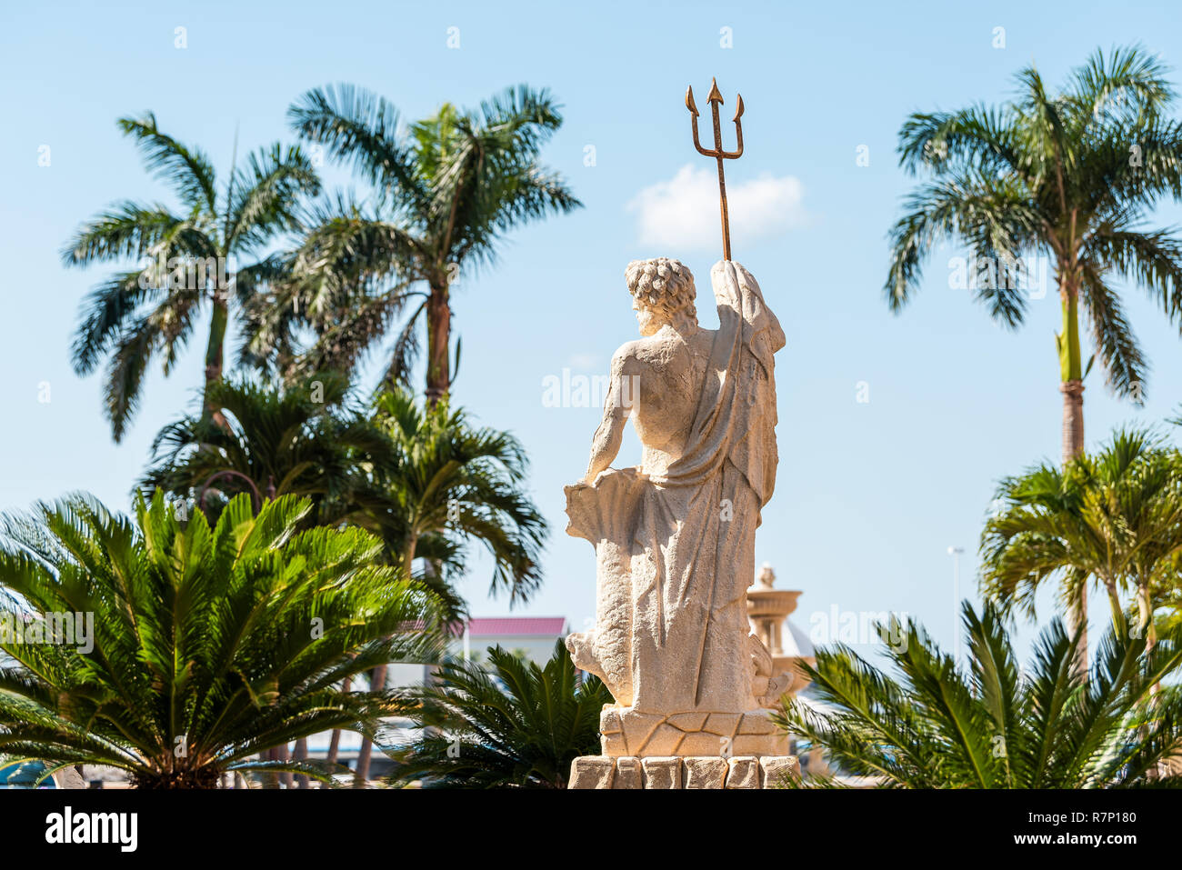Naples, USA - April 30, 2018: Bayfront residential community and shopping center with Neptune statue, sculpture fountain, palm trees, blue sky Stock Photo
