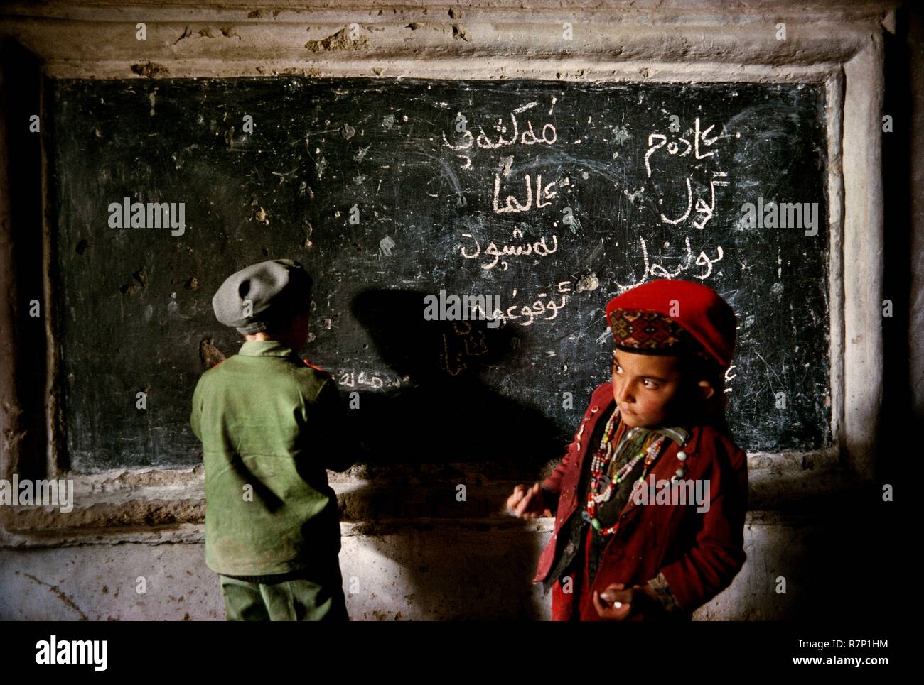 China, Xinjiang Autonomous Province, 1995 Two Tajik schoolchildren write on a blackboard in a classroom in Gurtuchlugh Stock Photo