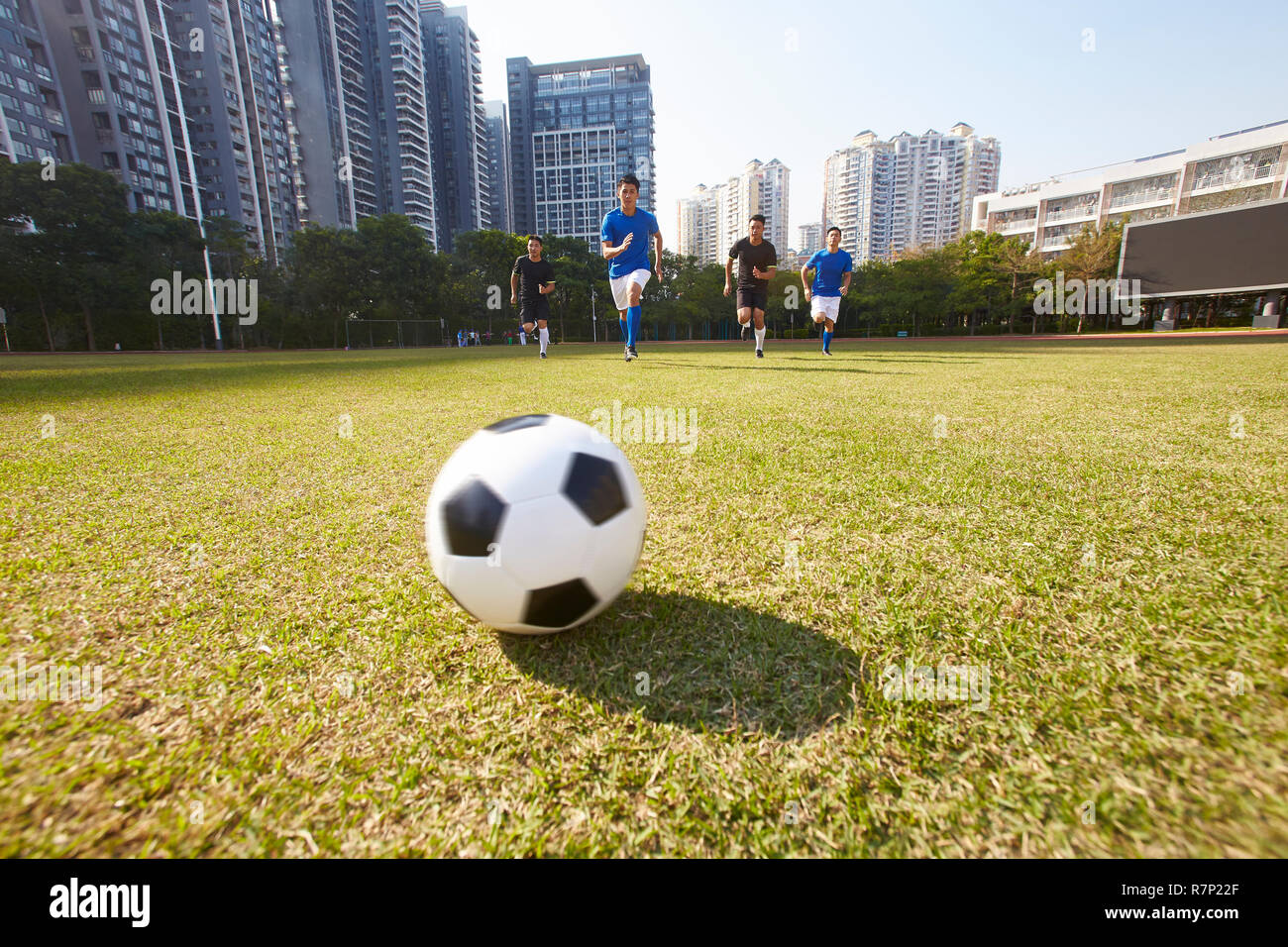 young asian soccer football players chasing the ball during a match Stock Photo