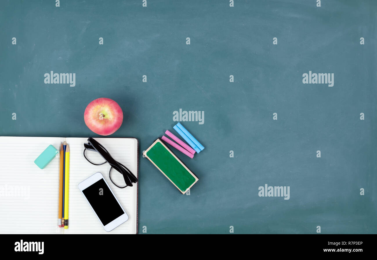 Back to school concept with the basic supplies on a green chalkboard Stock Photo