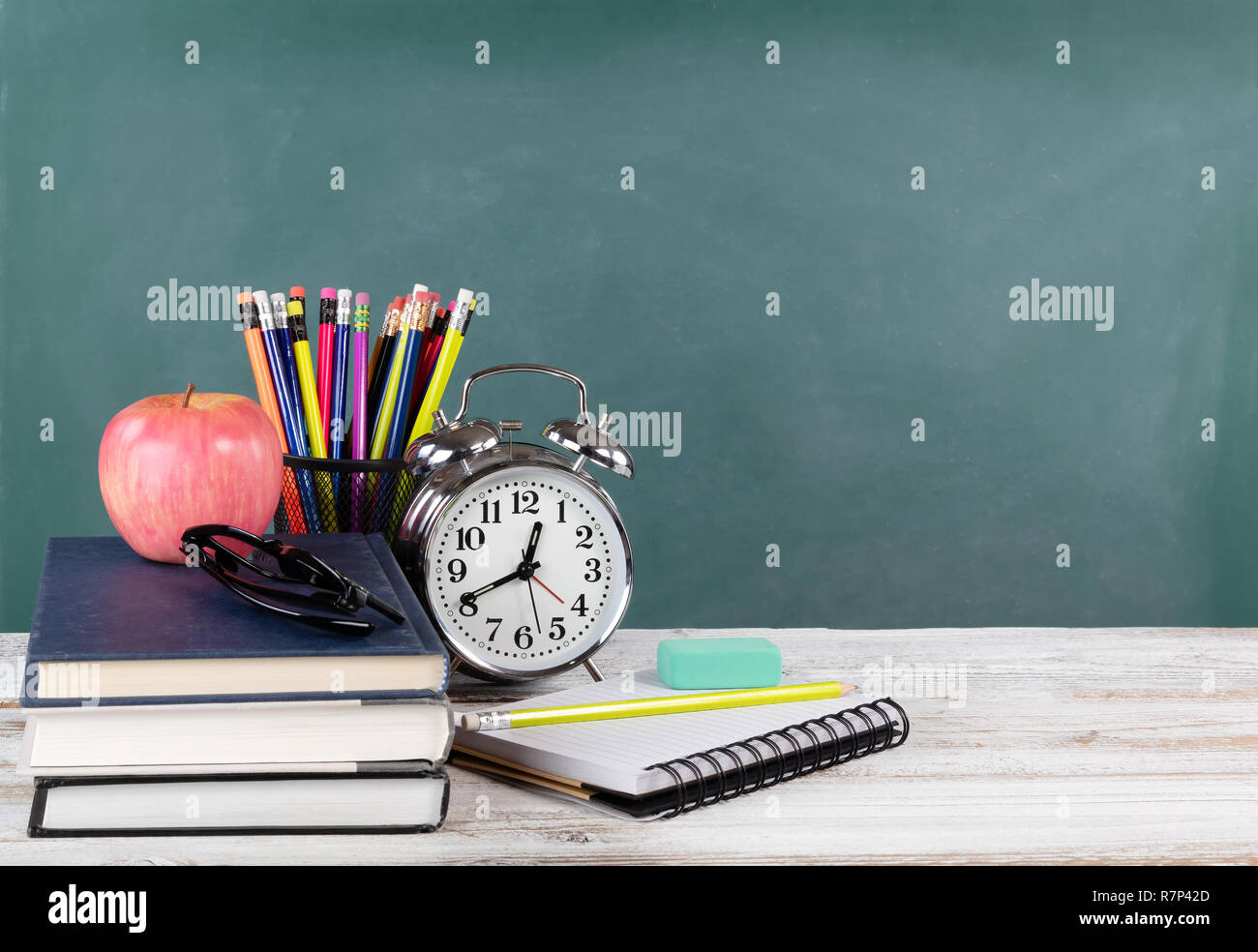 Time for back to school concept including books and stationery supplies with green chalkboard Stock Photo