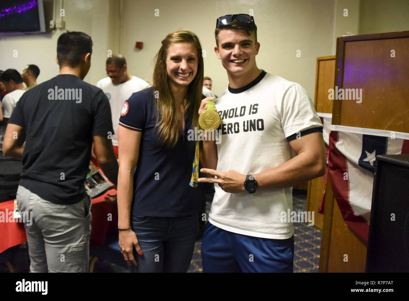 DIEGO GARCIA, British Indian Ocean Territory (Mar. 28, 2016) – Olympic gold medalist Katie Meili shows off her gold medal with Hospital Corpsman 3rd Class Anthony Sgroia during a meet and greet after an USO show. U.S. Navy Support Facility Diego Garcia provides logistic, service, recreational and administrative support to U.S. and Allied Forces forward deployed to the Indian Ocean and Arabian Gulf. Stock Photo
