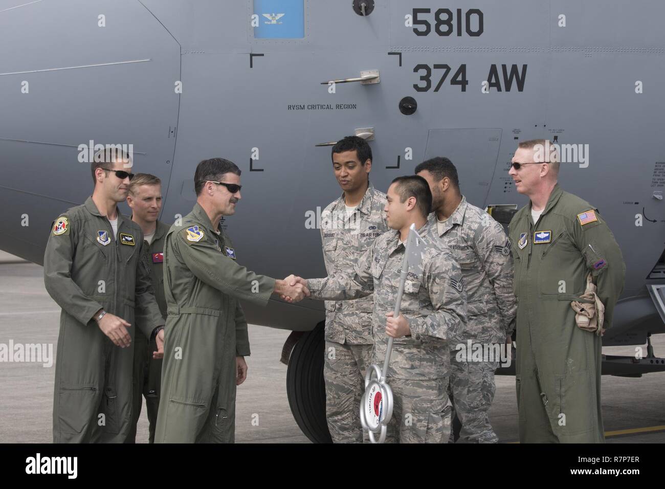 Col. Robert Dotson, 374th Operations Group commander, and Staff Sgt. Raymond Malig, 374th Aircraft Maintenance Squadron crew chief, shake hands in front of a C-130J Super Hercules at Yokota Air Base, Japan, March 29, 2017. This is the second C-130J delivered from Lockheed Martin, less than a month after the first was delivered March 6th. Yokota serves as the primary Western Pacific airlift hub for U.S. Air Force peacetime and contingency operations. Missions included tactical air land, airdrop, aeromedical evacuation, special operations and distinguished visitor airlift. Stock Photo