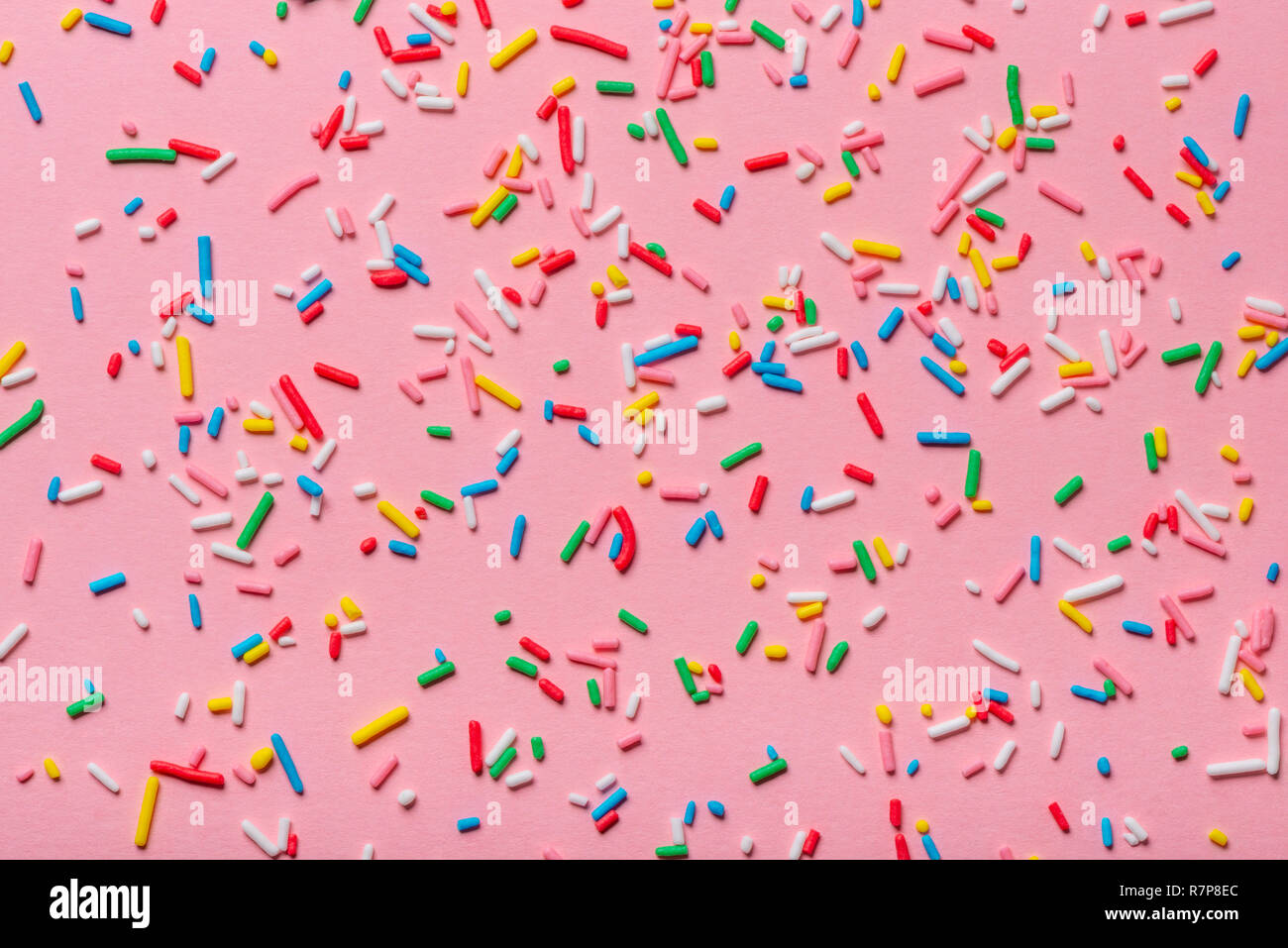 trendy pattern of colorful sprinkles over pink background, decoration