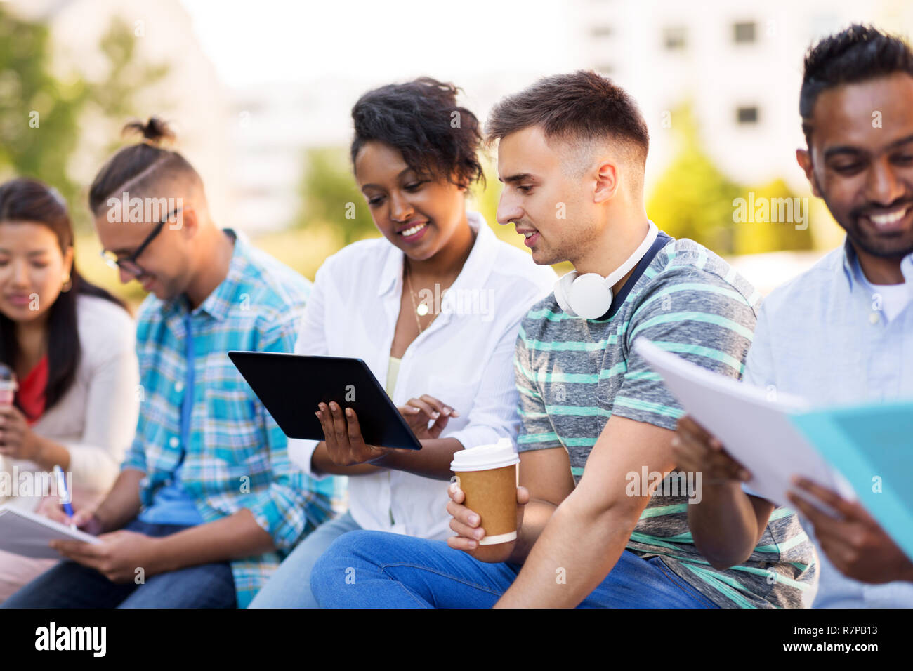 happy students with tablet pc and coffee outdoors Stock Photo
