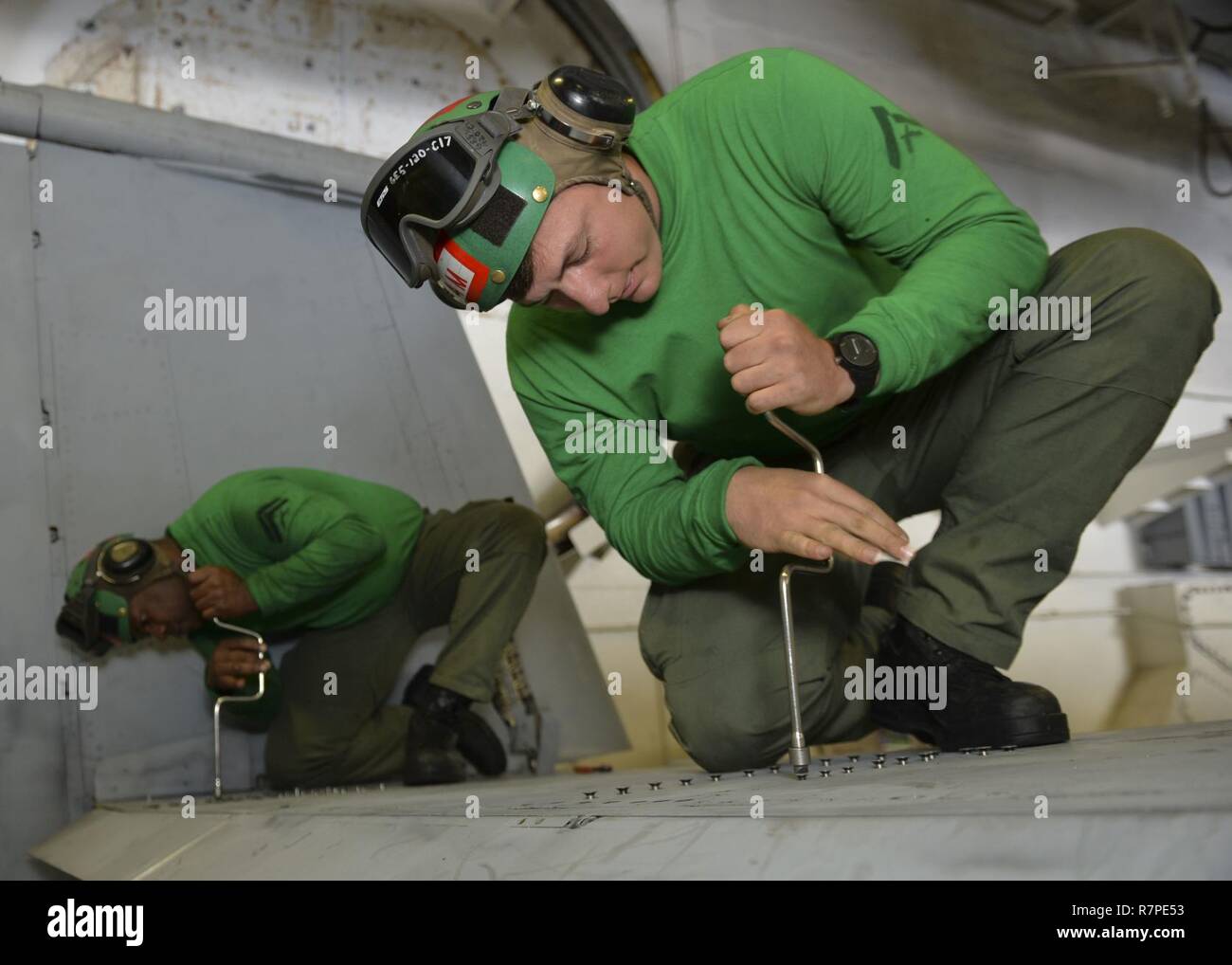 PACIFIC OCEAN (March 22, 2017) Cpl. Terrence Duncan, left, a native of Greensboro, N.C. and Lance Cpl. Jeremy Mosteller, a native of Vienna, Va., assigned to the 'Death Rattlers' of Marine Fighter Attack Squadron (VMFA) 323, perform maintenance on an F/A-18C Hornet aboard the aircraft carrier USS Nimitz (CVN 68). Nimitz is currently underway conducting Composite Training Unit Exercise (COMPTUEX) with the Nimitz Carrier Strike Group in preparation for an upcoming deployment. COMPTUEX tests a carrier strike group's mission-readiness and ability to perform as an integrated unit through simulated  Stock Photo