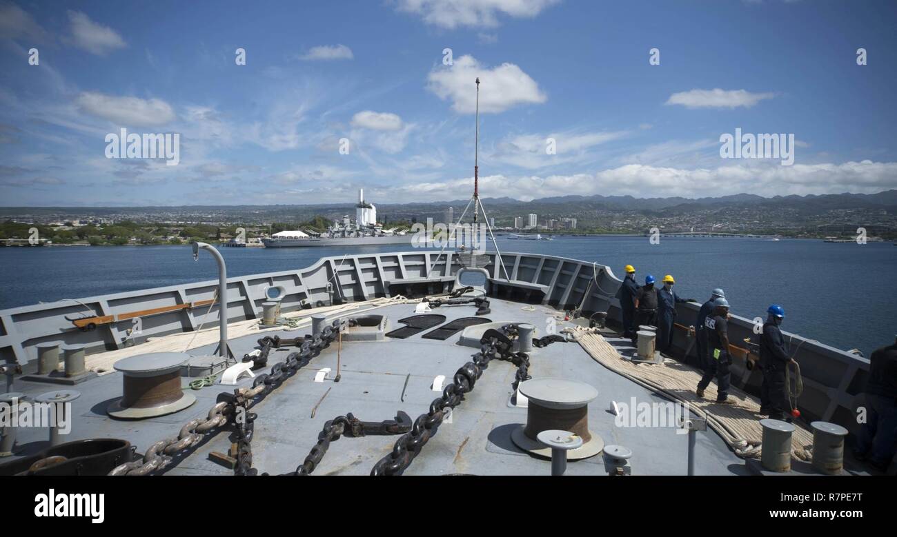 PEARL HARBOR (March 22, 2017) Sailors assigned to the submarine tender USS Frank Cable (AS 40) prepare to throw mooring lines as the ship arrives at Pearl Harbor. Frank Cable is en route to Portland, Oregon, for its dry-dock phase maintenance availability. Stock Photo