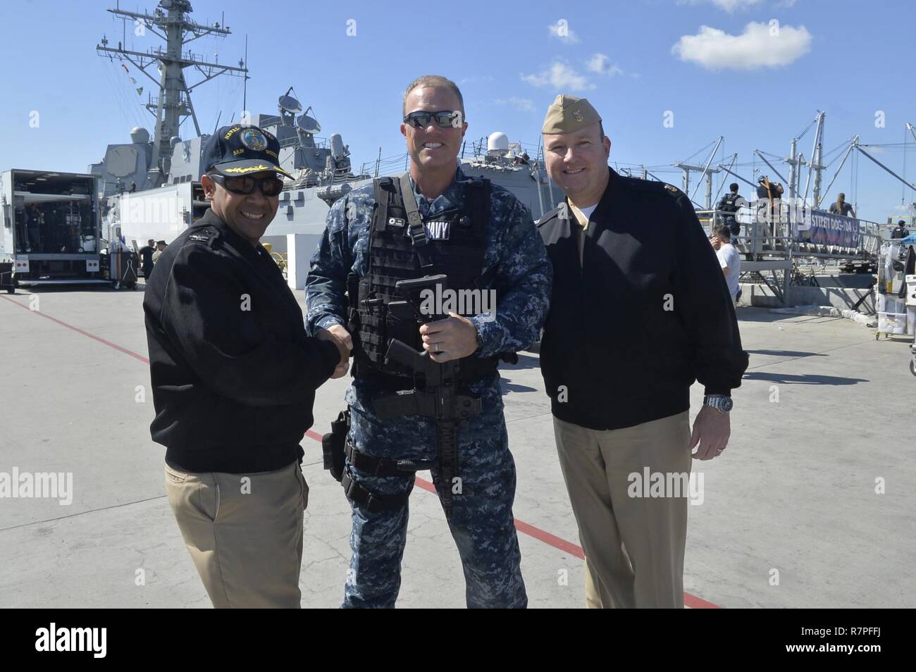 SAN DIEGO (March 23, 2017) Naval Base San Diego Commanding Officer Capt. Roy Love, left, and Command Master Chief Matt Ruane greet actor Adam Baldwin prior to the filming of the television show 'The Last Ship'. Stock Photo