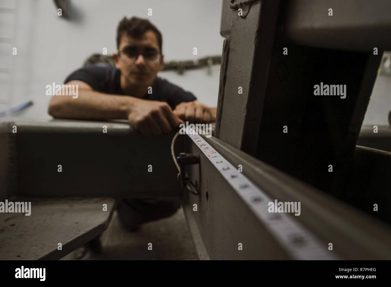 PHILIPPINE SEA (March 25, 2017) Seaman Ali Daouk, from Miami, conducts maintenance in the boat valley of the amphibious transport dock ship USS Green Bay (LPD 20). Green Bay, part of the Bonhomme Richard Expeditionary Strike Group, with embarked 31st Marine Expeditionary Unit, is on a routine patrol, operating in the Indo-Asia-Pacific region to enhance partnerships and be a ready-response force for any type of contingency. Stock Photo